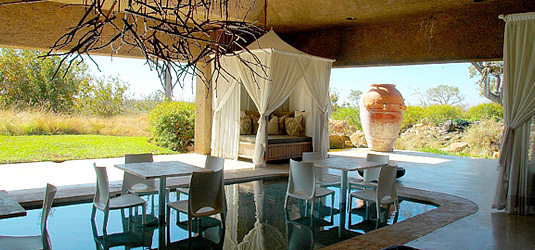 Relax at the Day Bar area, the tables are right inside the pool, cooling your feet in ankle deep water at Earth Lodge, Sabi Sabi, Sabi Sand Private Game Reserve
